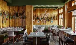 Interior view of a restaurant with wooden walls tables chairs and wall decorations
