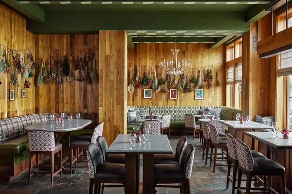 Interior view of a restaurant with wooden walls tables chairs and wall decorations