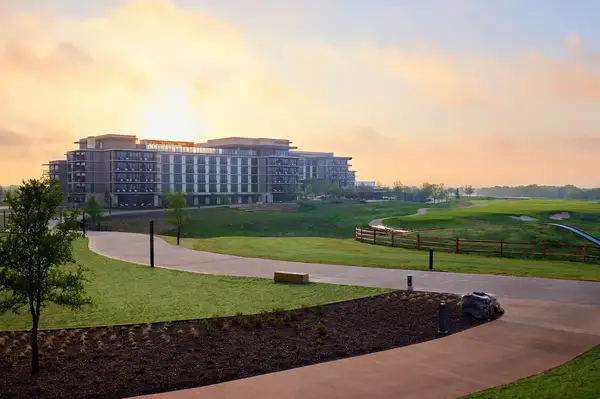 Hotel resort building and landscaped grounds with pathways and open green spaces