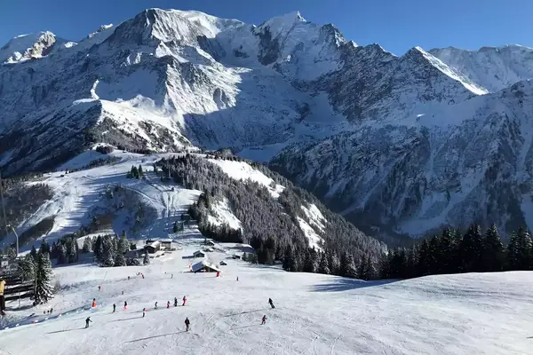 People skiing in the shadow of large mountains in Chamonix