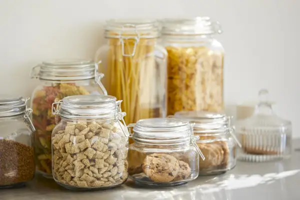 close up of various food in airtight jars groceries are seen through glass containers eatables are on table