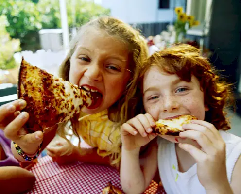 girls eating pizza at table