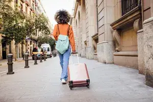 Woman walking alone with suitcase in Barcelona, Spain