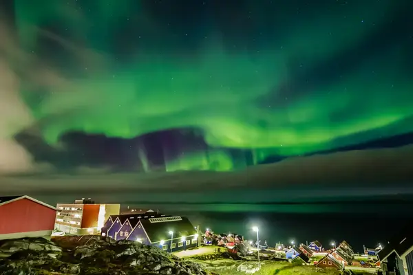 View of Aurora Borealis over a small town at night
