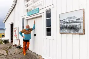 Woman in colorful sweater standing against a white building