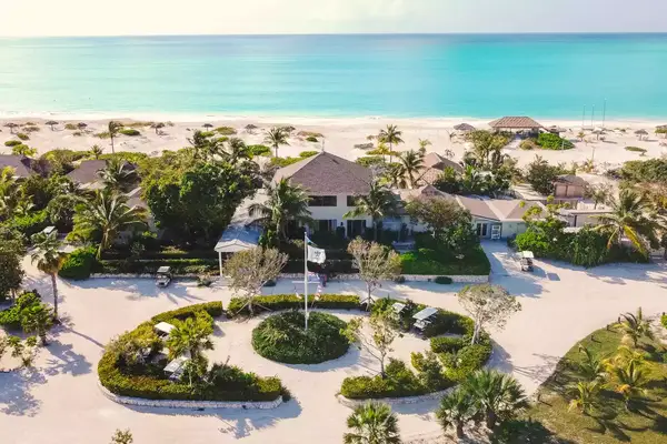 aerial of resort enterance with tall white flag pole in front of main opening 