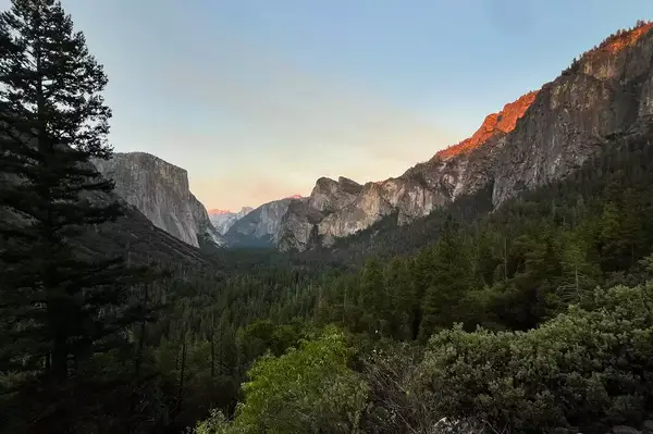 A scenic view of Yosemite Valley with surrounding cliffs and forested areas