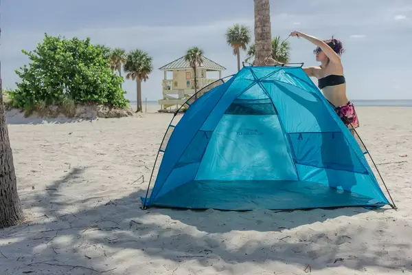 Person unzipping the outer window of the Sport-brella Premiere UPF 50+ Umbrella on the beach