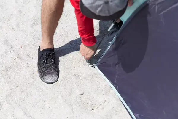Closeup of a person adjusting the pole for the WhiteFang 3-Person Beach Tent