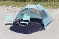 WhiteFang Beach Tent set up on a beach with two beach chairs