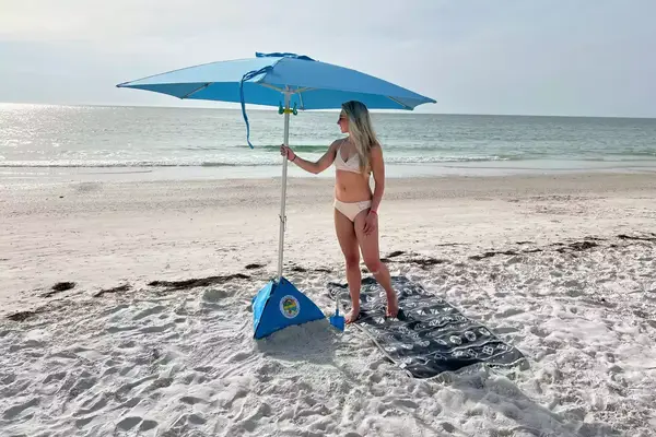 Person setting up beachBUB All-In-One Beach Umbrella System on beach