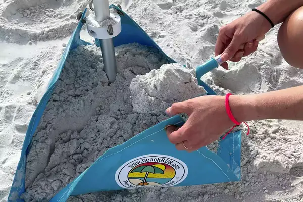 Person weighing down beachBUB All-In-One Beach Umbrella System