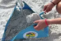 Person weighing down beachBUB All-In-One Beach Umbrella System