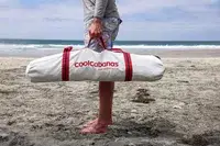 A person carries the CoolCabanas CoolCabana 5 rolled up in a storage bag