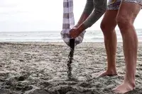 A person dumps sand out of the CoolCabanas CoolCabana 5