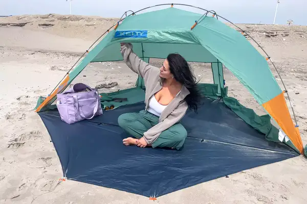 A person sits inside the Kelty Cabana Shelter