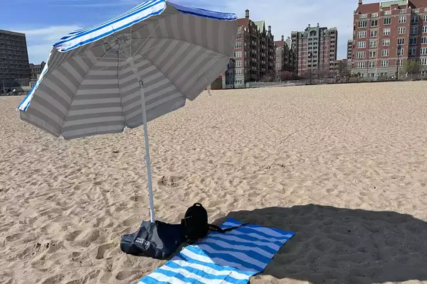 Person setting up beachBUB All-In-One Beach Umbrella System on beach