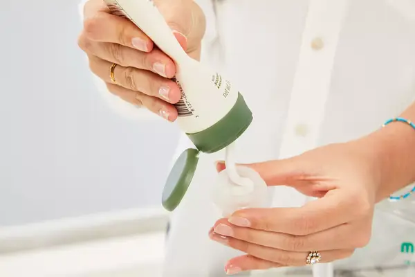 Person dispensing product into Morfone 16 Pack Travel Bottle