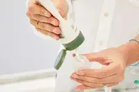 Person dispensing product into Morfone 16 Pack Travel Bottle