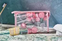 Vitog Travel Bottles and pouch sitting on a bathroom counter