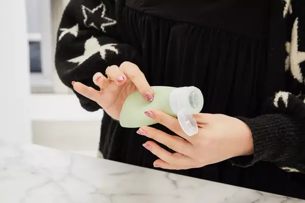 Person squeezing a INSFIT TSA Carry-on Approved Container