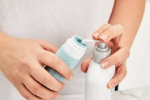 Person filling the Mrsdry Travel Bottle with product