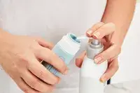 Person filling the Mrsdry Travel Bottle with product