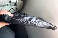 A person holding the Beskar Airplane Foot Rest in the carry bag
