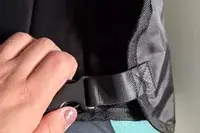 A person unclasping the buckle on the Beskar Airplane Foot Rest