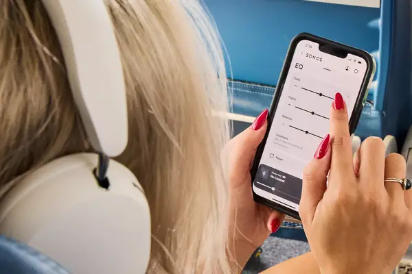 A person wearing the Sonos Ace Headphones while using the app