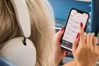 A person wearing the Sonos Ace Headphones while using the app