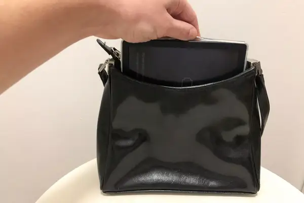 A hand pulling the Kobo Libra Colour out of a handbag