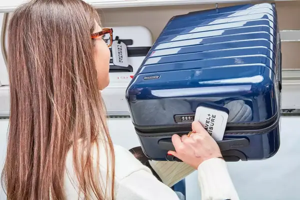 Person stowing the Away The Carry-On in the overhead compartment on an airplane