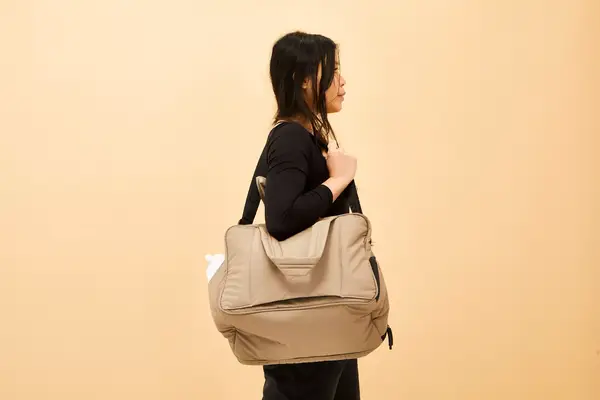 A person carrying the Calpak Luka Duffel Bag on their shoulder