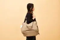A person carrying the Calpak Luka Duffel Bag on their shoulder