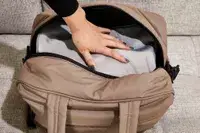 A hand pressing an item into the Calpak Luka Duffel Bag
