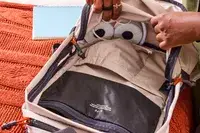 A person places headphones into the Bellroy Lite Daypack