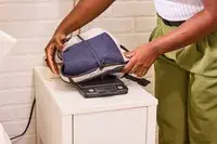 A person weighs the Bellroy Lite Daypack