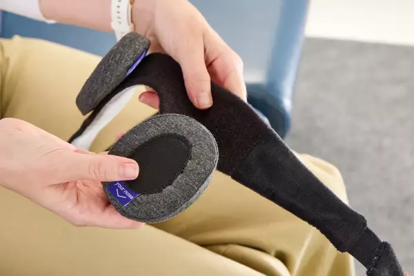 A person touching the eye pads of the Manta Sleep Mask