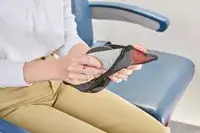 A person removing the Manta Sleep Mask from a travel pouch