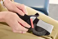 A person adjusting the velcro strap on the Manta Sleep Mask