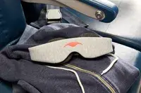 The Manta Sleep Mask laid out on an airplane seat