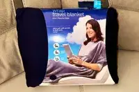 Travelrest 4-in-1 Travel Blanket displayed in its packaging on a gray surface