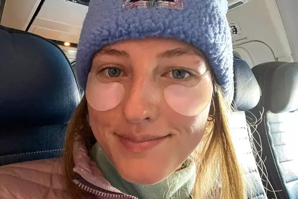 A person sitting in an airplane wearing the Knesko Diamond Radiance Collagen Eye Mask