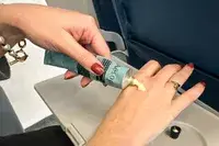 A person applying Aēsop Reverence Aromatique Hand Balm to the back of their hand