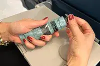 A person unscrewing the lid to the Aēsop Reverence Aromatique Hand Balm
