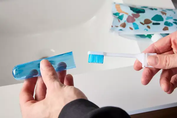 A person removing the lid from the Spark Dental Co. Toothbrush
