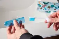 A person removing the lid from the Spark Dental Co. Toothbrush