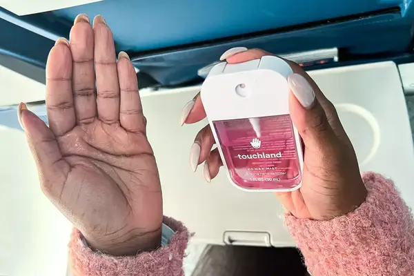 A person applying the Touchland Power Mist Hand Sanitizer