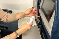 A person removing the lid of the Evian Facial Spray